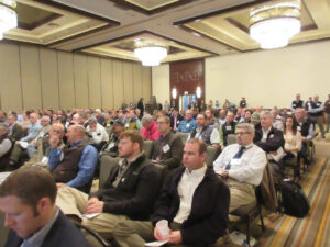 Photo of several dozens of attendees sitting and listening intently to a speaker at a past Beltwide Cotton Conference.